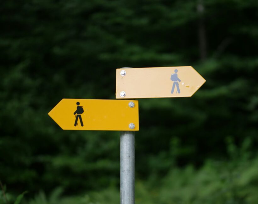 two yellow signs pointing in two directions