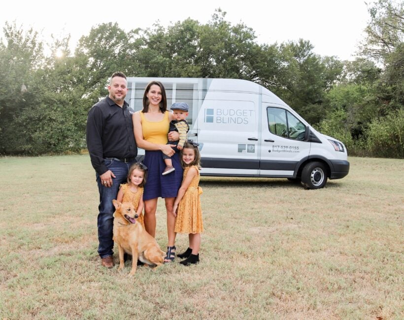 Budget blinds van with family standing in front of it