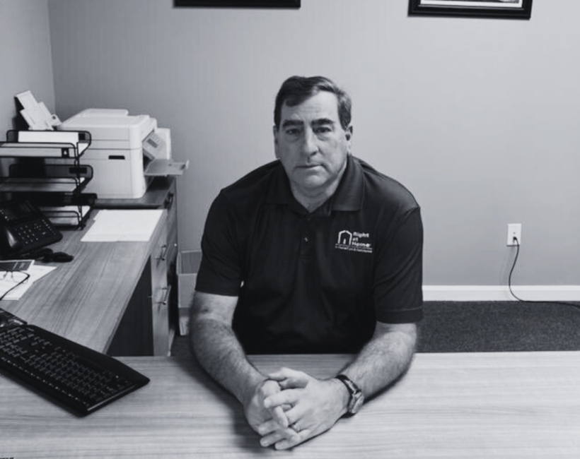Man sitting at desk with hands clasped