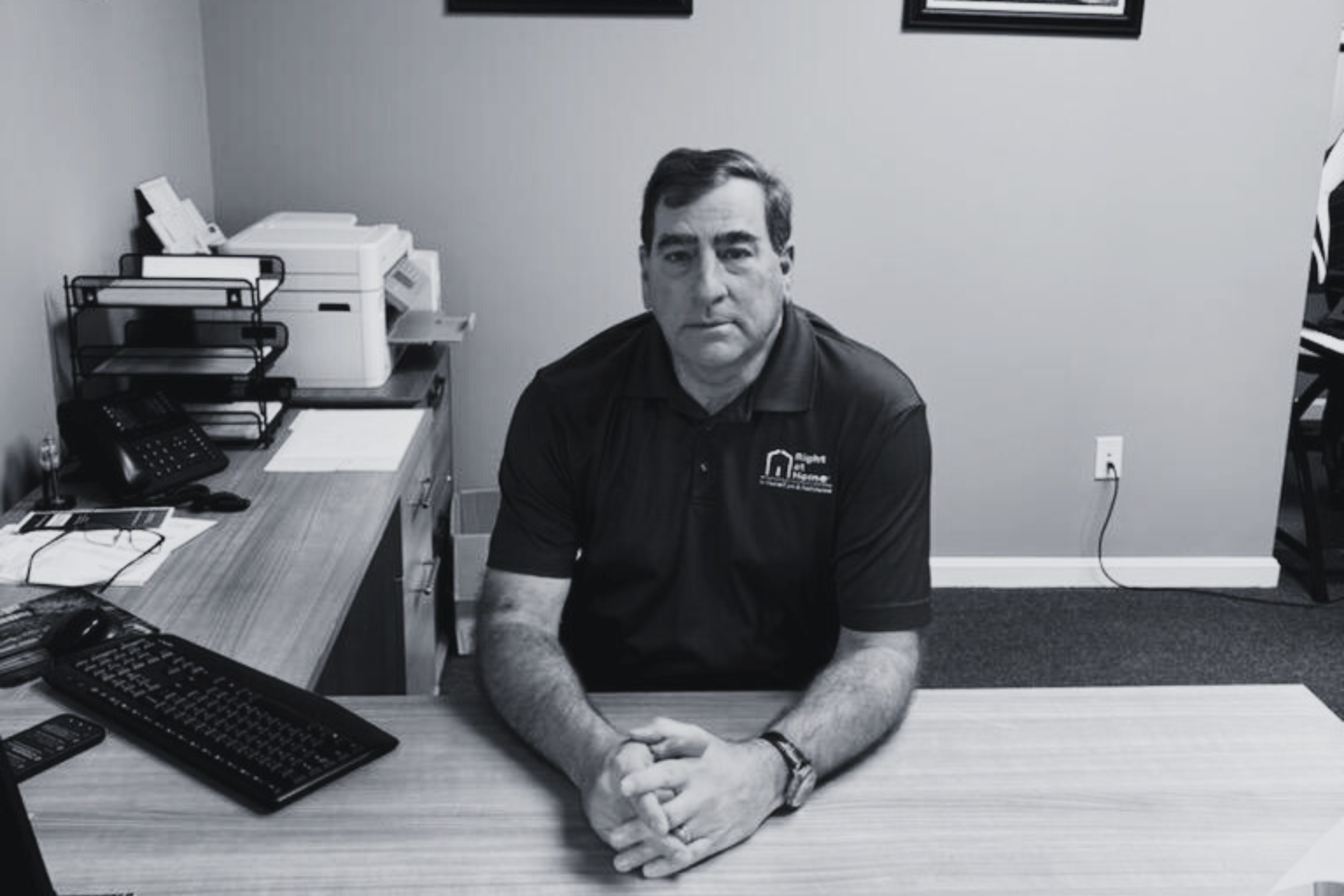 Man sitting at desk with hands clasped