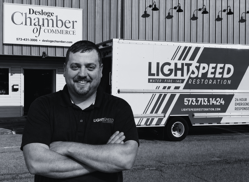 Mark Curfman, Lightspeed Restoration franchisee, standing in front of a truck